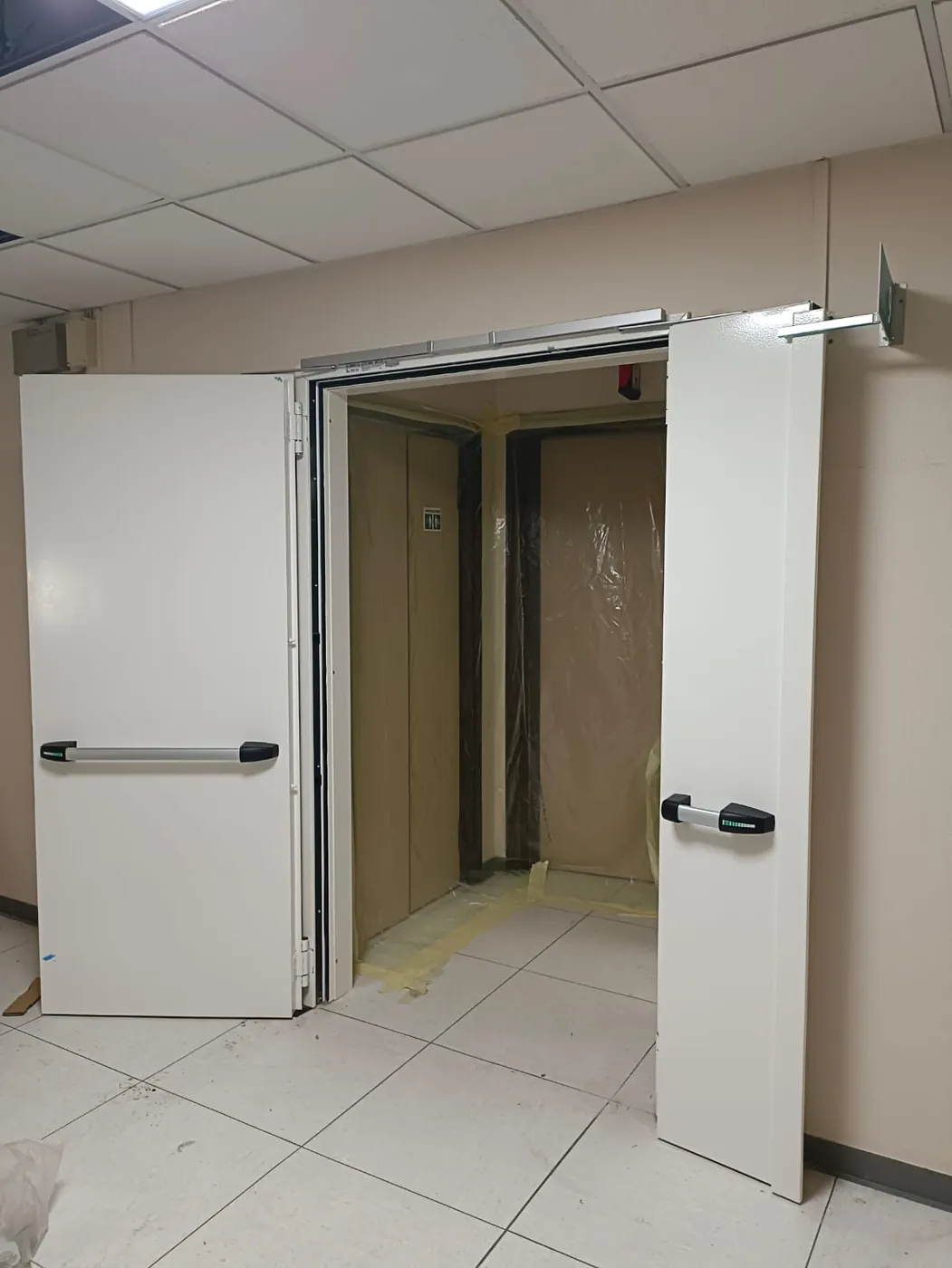 Porta a due ante aperta su un locale ancora in lavorazione